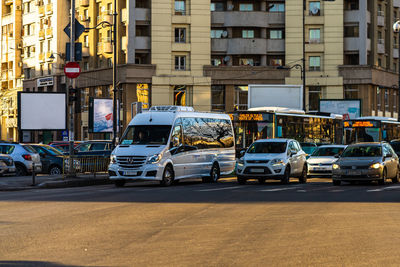 Traffic on road by buildings in city