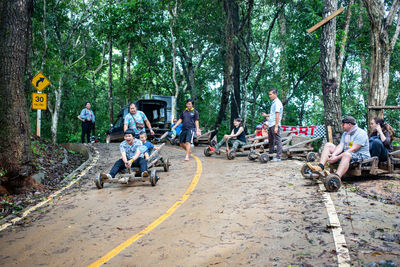 People on road amidst trees in forest