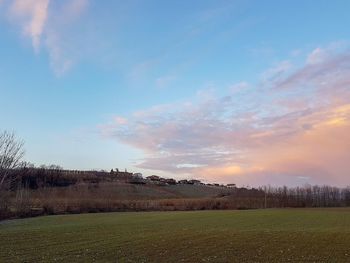 Scenic view of field against sky during sunset