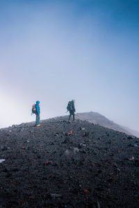 Male hikers hiking on mountain during winter