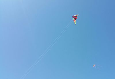 Low angle view of vapor trail against clear blue sky