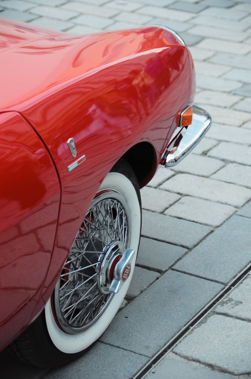 transportation, car, mode of transportation, vehicle, automobile, red, motor vehicle, land vehicle, wheel, sports car, tire, day, luxury vehicle, street, no people, city, outdoors, cobblestone, high angle view, paving stone