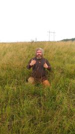 Full length of man with arms raised on field