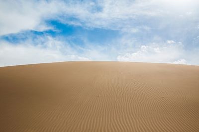 Sand dunes in desert against sky