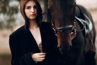 Portrait of young woman with horse