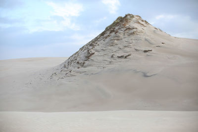 Sand dunes in desert against sky