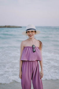 Portrait of young woman standing at beach