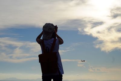Rear view of woman standing against sky
