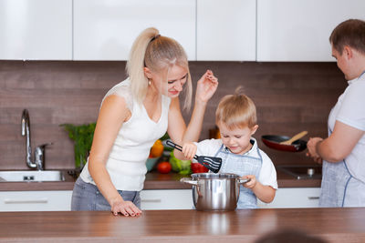 Dad, mom and their little son are preparing dinner. happy family preparing