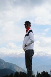 Portrait of man standing on mountain against sky