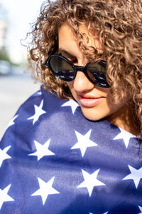 Portrait of young woman wearing sunglasses with american flag