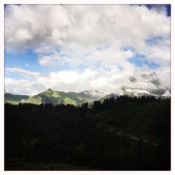 Scenic view of mountains against cloudy sky