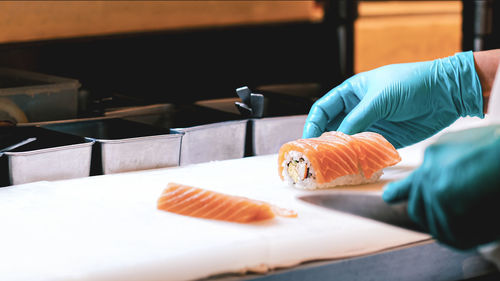 Chef holding salmon on kitchen knife in restaurant