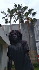 Portrait of man standing on palm tree