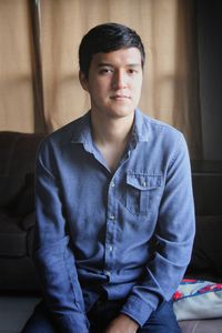 Portrait of young man sitting on sofa at home