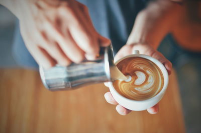 Cropped image of hand holding coffee cup