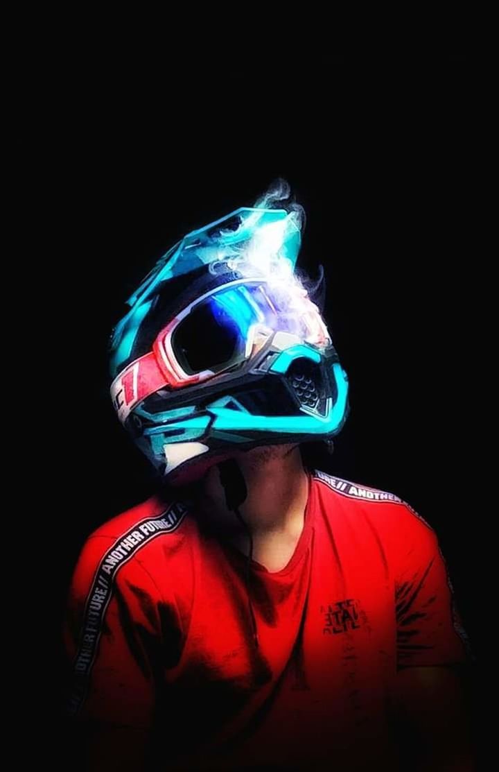 one person, black background, studio shot, portrait, adult, headshot, indoors, clothing, helmet, front view, headwear, red, mask, disguise, young adult, waist up, copy space, mask - disguise, sports, darkness