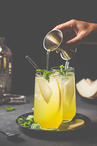 Cropped hand holding drink on table