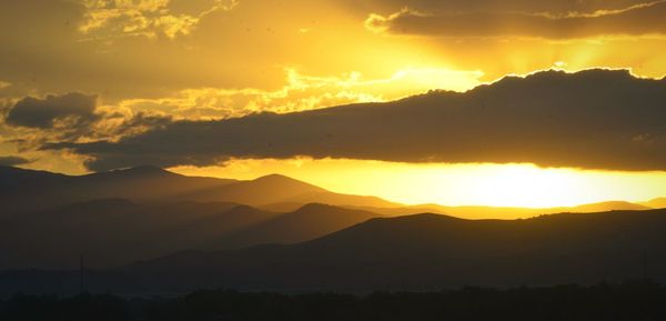 Scenic view of silhouette mountains against sky at sunset