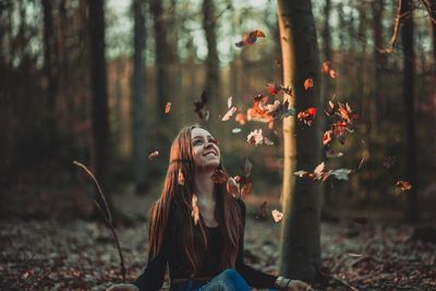 Portrait of smiling young woman in forest