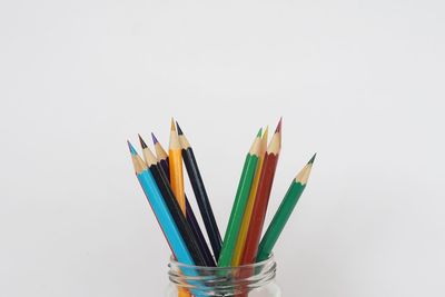 Close-up of multi colored pencils against white background