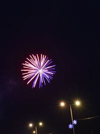 Low angle view of illuminated fireworks against sky at night