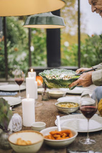 Senior man setting table for dinner party