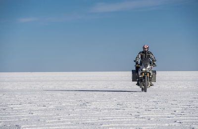 Man riding his touring motorbike on the salt flats of uyuni in bolivia