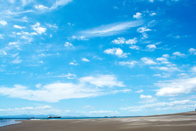 Scenic view of beach against blue sky