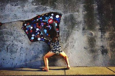 Midsection of woman standing against wall