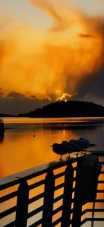 Scenic view of lake against orange sky