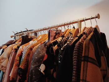 Close-up of clothes hanging by wall at store