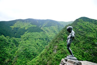 Statue on mountain against sky