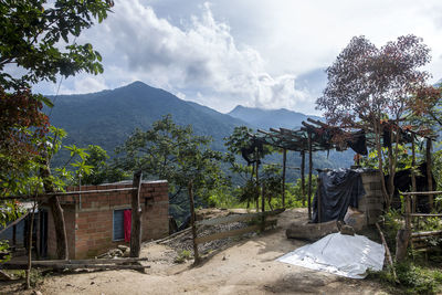 Built structure by trees and buildings against sky