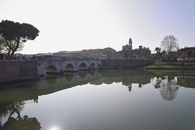 Arch bridge over river against sky