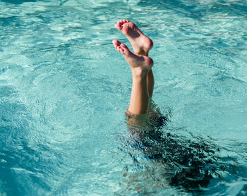 Low section of person swimming in pool