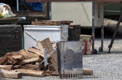 Camping stove by logs on field during camping