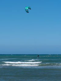 Kitesurfing during a windy day with a very rough sea.