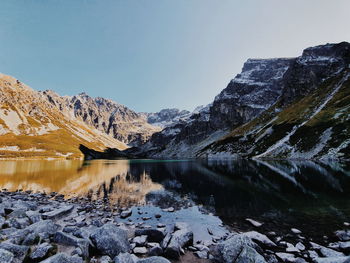 Scenic view of lake and mountains against clear sky