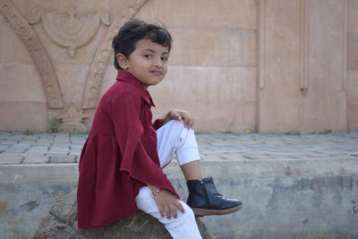 Girl looking away while sitting on floor