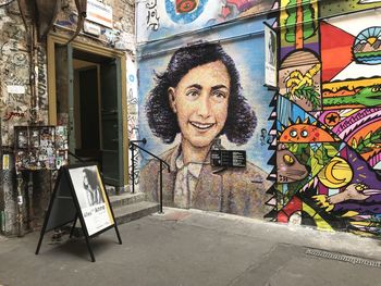 Portrait of smiling woman against graffiti wall