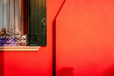 Detail of red colored houses with burano window with shadow