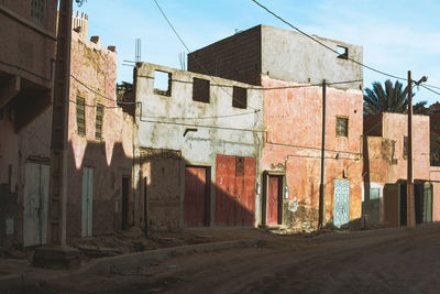 Ghost town in sahara desert with decadent abandoned house and dirt sand road, morocco