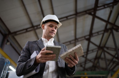 Male worker of factory picking marble samples