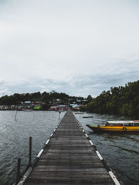 Pier over river against sky