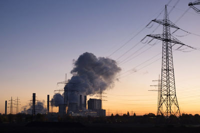 Low angle view of smoke emitting from factory against clear sky