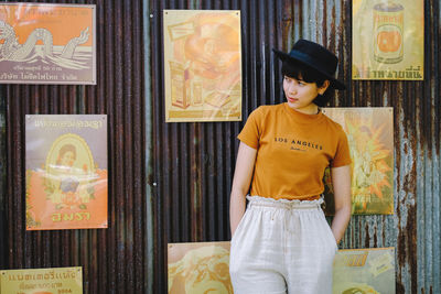 Full length of young man standing against wall