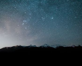 Low angle view of silhouette mountain against sky at night