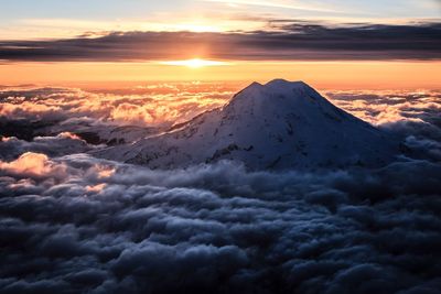 Idyllic shot of mt rainier amidst clouds against sky during sunset