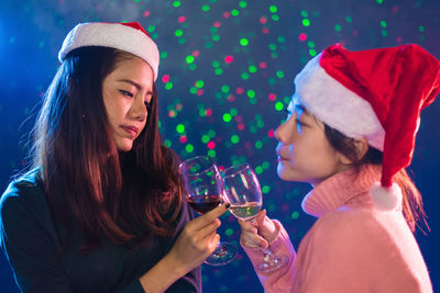 Close-up of female friends toasting during christmas